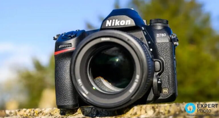 Nikon D780 de face, logo Nikon et inscription D780 lisibles, objectif 50 mm f/1.8G monté, bokeh bleu-vert en arrière-plan