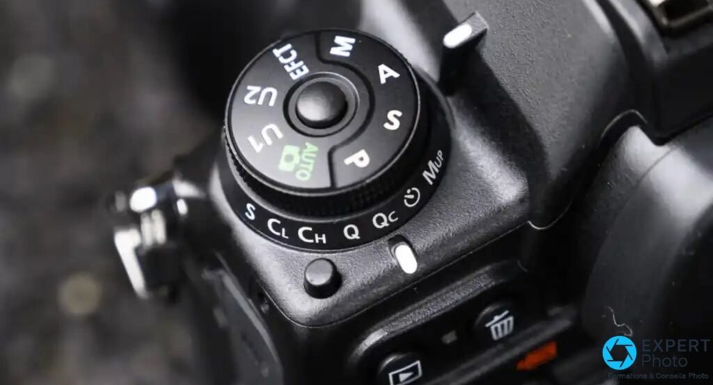 Nikon D780 molette modes gros plan, positions M A S P AUTO U1 U2, sélecteur cadence S CL CH Q Qc et MUP visibles
