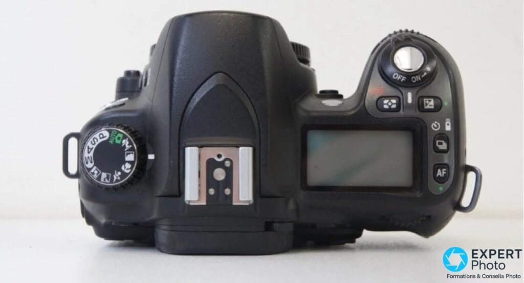 Vue dessus du Nikon D80 : molette M-A-S-P-AUTO, sabot flash, écran LCD supérieur et bouton AF