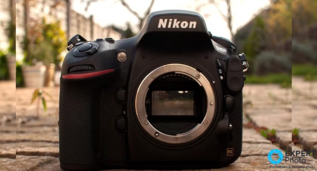 Nikon D800 reflex plein format boîtier nu de face, monture Nikon F ouverte, fond jardin en bokeh