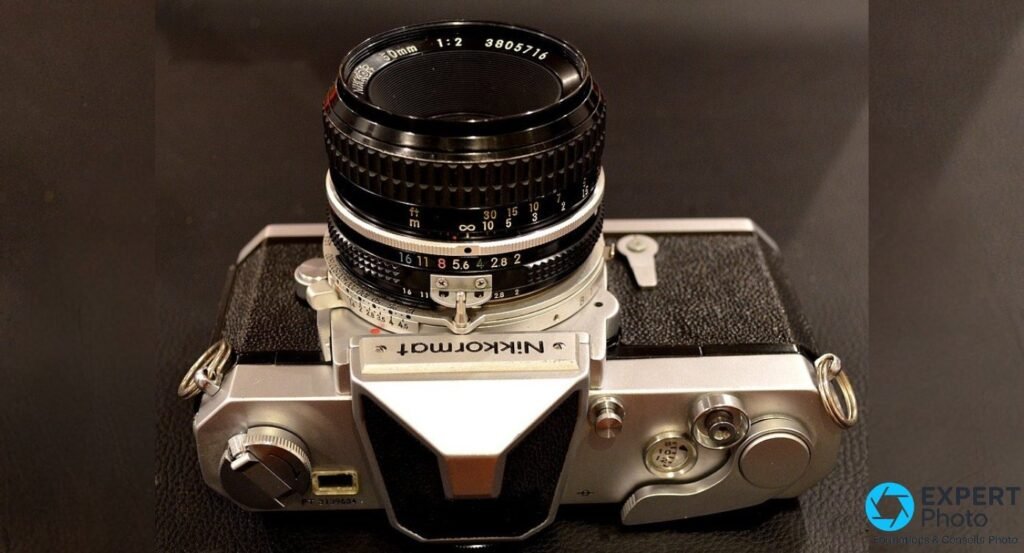 Nikon Nikkormat FT chromé avec Nikkor 50 mm f/2 monté, vue trois-quarts face avant, plaque Nikkormat visible