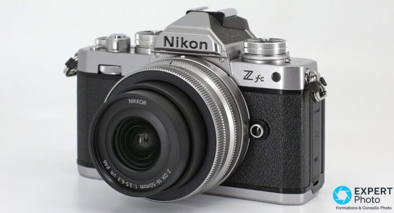 Nikon Z fc argenté équipé du NIKKOR Z DX 16-50 mm VR, vue trois quarts avant droit, fond studio blanc.