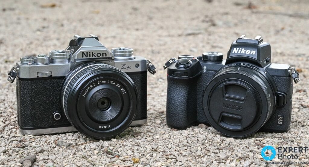 Nikon Z fc argenté avec NIKKOR Z 28 mm f/2.8 SE à gauche, Nikon Z50 noir avec cache objectif à droite, sur gravier.