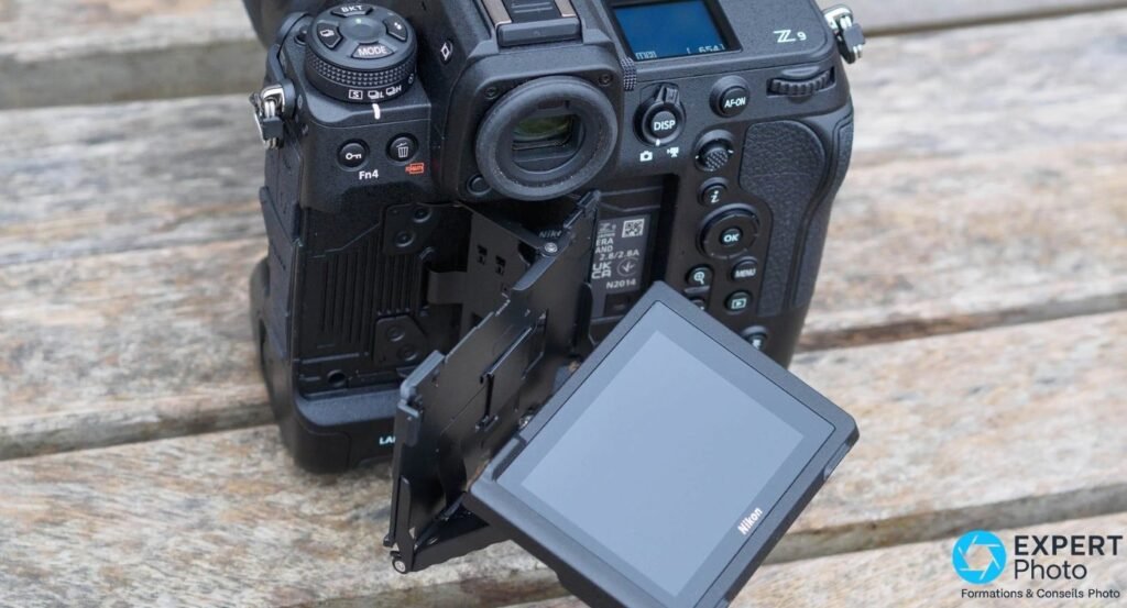 Nikon Z9 vu de trois quarts arrière, écran LCD orientable 4 axes déployé sur le côté droit, sur planches de bois