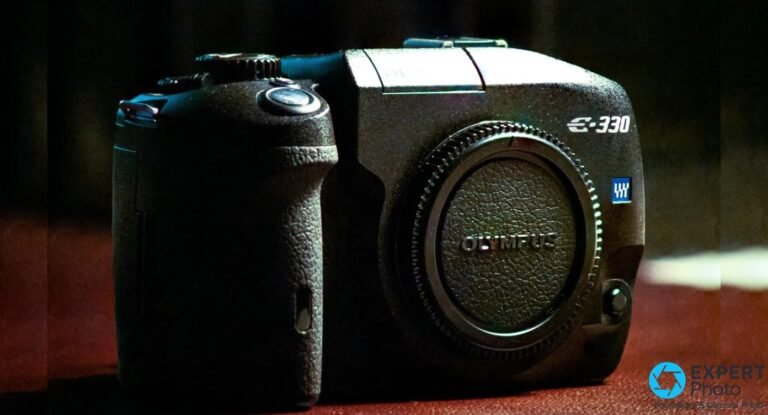 Olympus E-330 vu strictement de face, bouchon de monture noir avec logo OLYMPUS gravé, grip caoutchouc