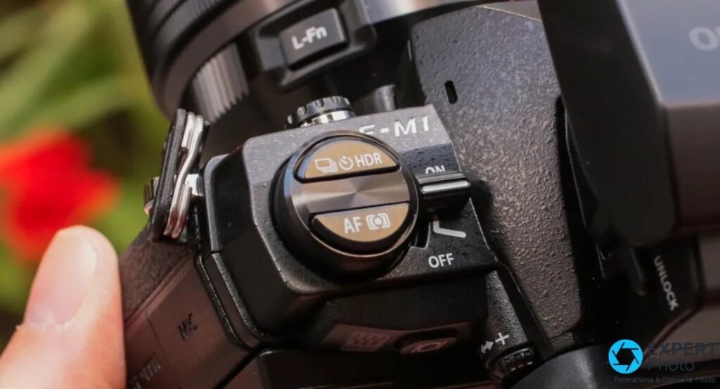 Gros plan sur le bloc de commandes droit de l'Olympus OM-D E-M1 : boutons HDR, AF, interrupteur ON/OFF et L-Fn.
