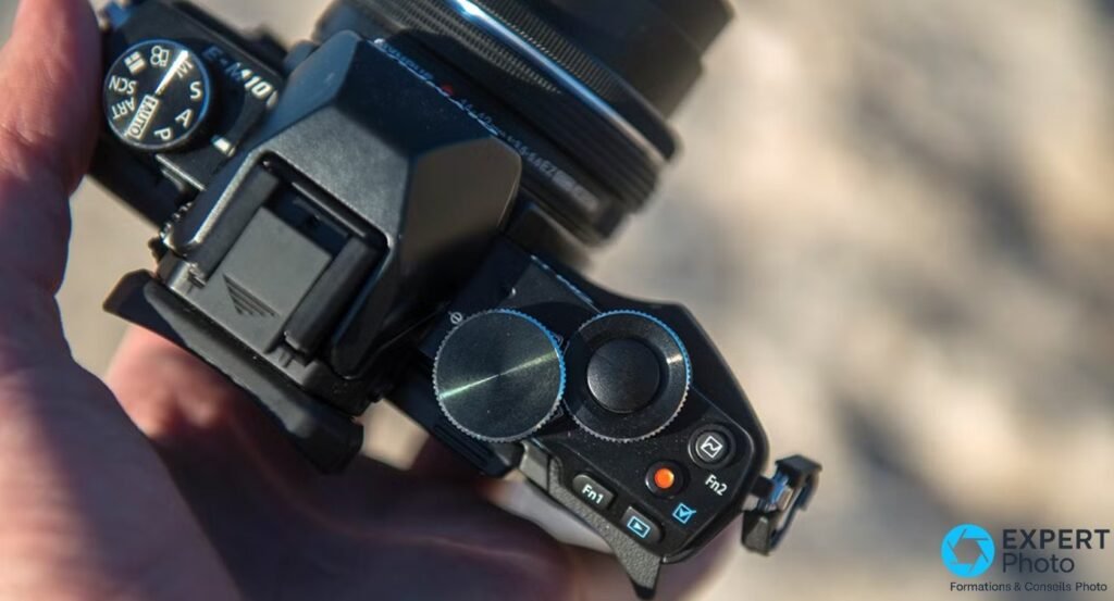 Vue du dessus de l'Olympus OM-D E-M10 : gravure E-M10, molette de modes, doubles molettes et boutons Fn1 Fn2