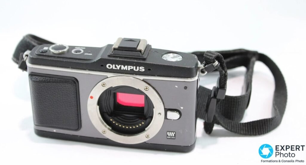 Olympus PEN E-P2 gris anthracite et noir, boîtier nu sans objectif, monture Micro Four Thirds, sangle à droite.