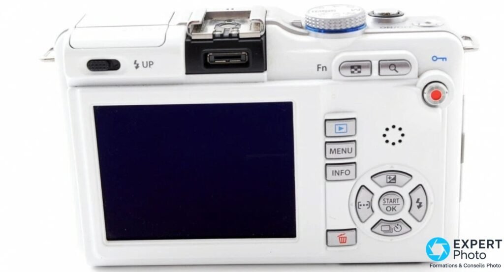  Dos de l'Olympus PEN E-PL1 blanc : écran LCD, boutons MENU INFO, molette directionnelle et port AP2 sous le hot shoe. 
