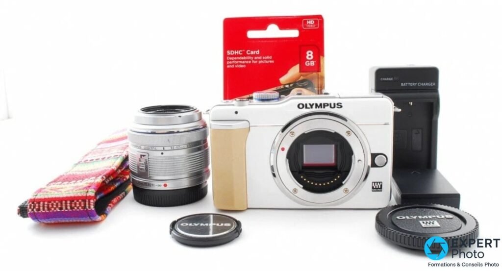 Kit Olympus PEN E-PL1 : boîtier blanc, zoom M.Zuiko 14-42 mm silver, chargeur, carte SDHC 8 Go et sangle textile.