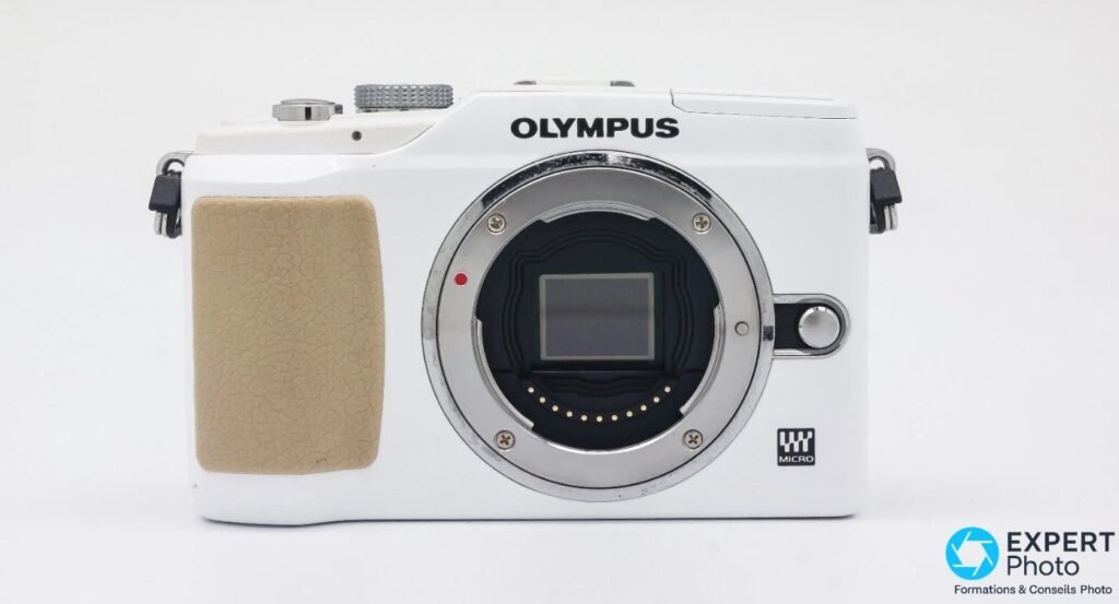 Olympus PEN E-PL2 blanc de face, monture Micro 4/3 ouverte, capteur Live MOS visible