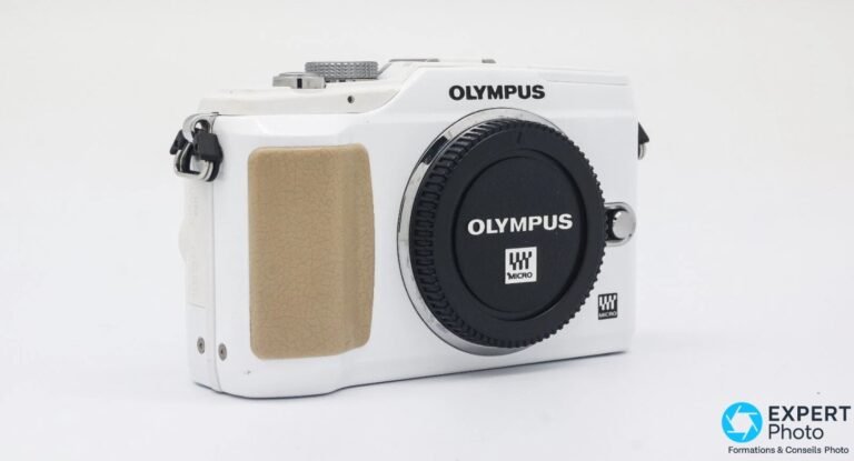 Olympus PEN E-PL2 blanc de 3/4 avant droite, cache d'objectif noir Olympus Micro 4/3 monté