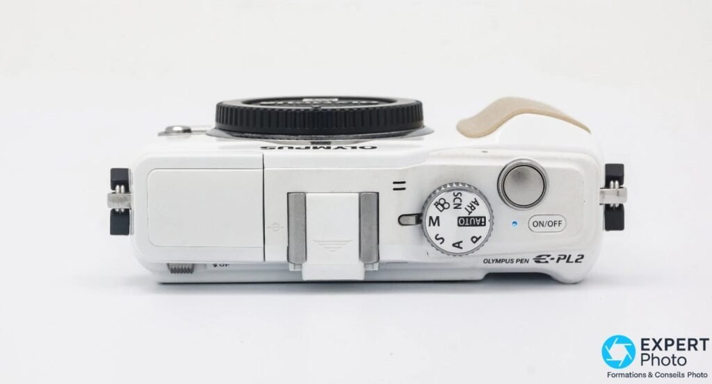 Olympus PEN E-PL2 vu du dessus, molette de modes PASM, bouton ON/OFF, nom du modèle gravé