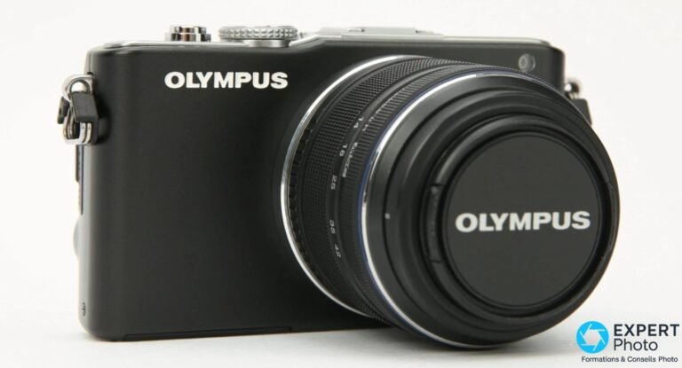 Boîtier Olympus PEN E-PL3 noir avec objectif kit 14-42 mm et cache OLYMPUS, vu de trois-quarts avant, fond blanc.