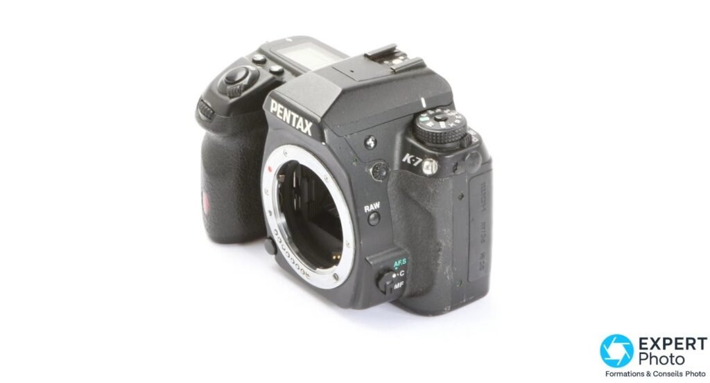 Boîtier Pentax K-7 noir vu de trois-quarts avant droit, monture K-mount ouverte sans objectif, marquages PENTAX et K-7.