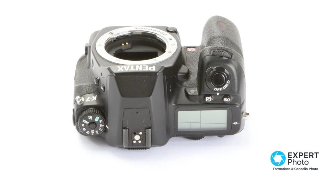Dessus du Pentax K-7, molette de mode avec positions USER, P, Sv, Tv, Av, M, B, X, top LCD et griffe flash.