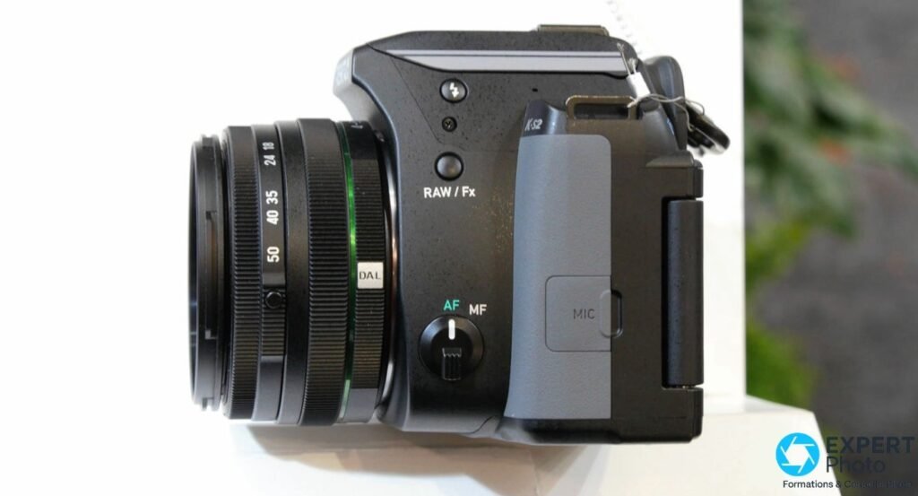 Pentax K-S2 flanc droit avec griffe flash ouverte, fente carte SD avec éjection, trappe HDMI et USB ouverte