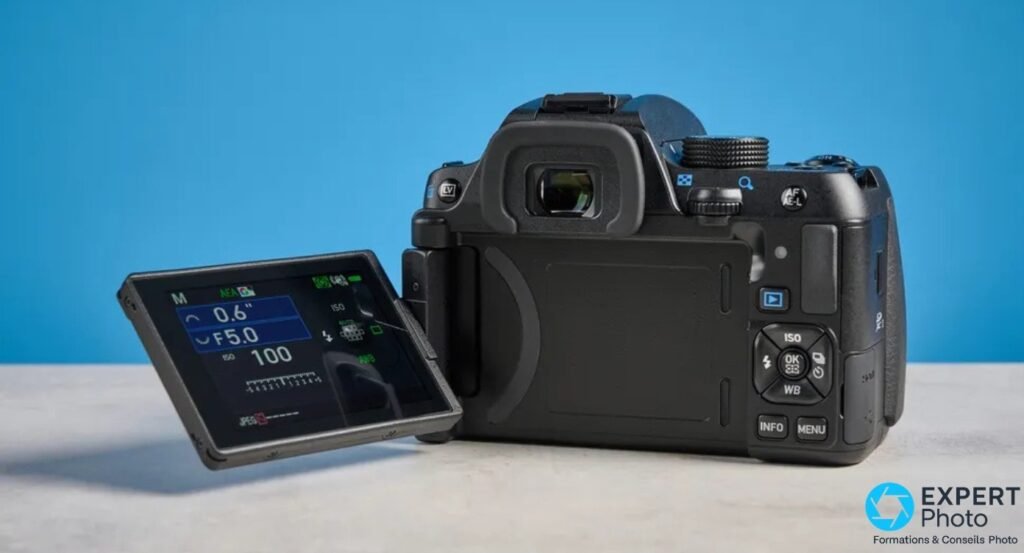 Pentax KF vue arrière studio, écran orientable déployé affichant mode M avec F5.0, ISO 100 et vitesse 0,6 s