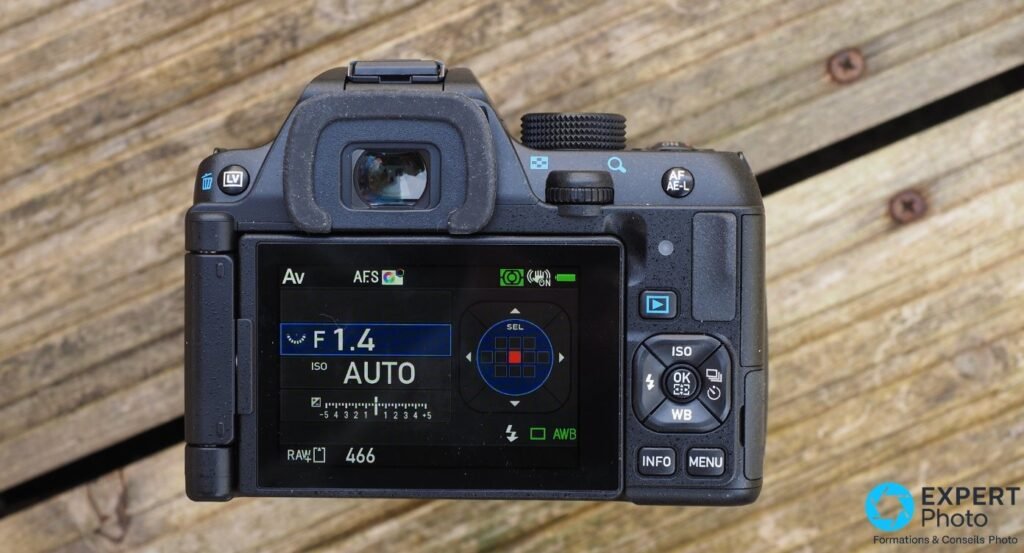 Pentax KF vu de dos, écran Status Screen en mode Av affichant F 1.4 et ISO AUTO, viseur et boutons visibles