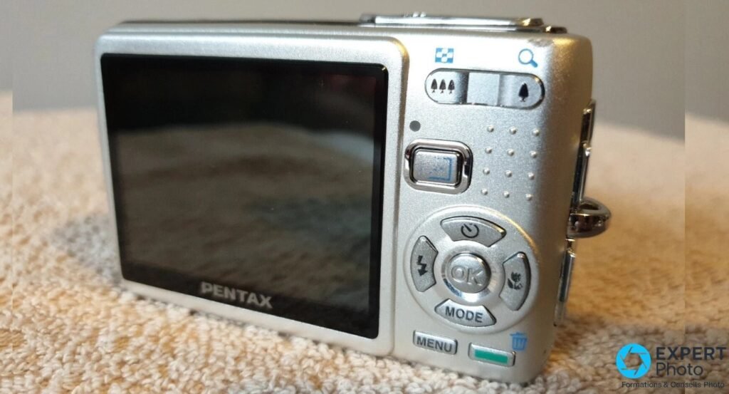 Vue arrière du Pentax Optio A10 : écran LCD, bascule zoom W/T, pavé directionnel avec OK, MODE et MENU.