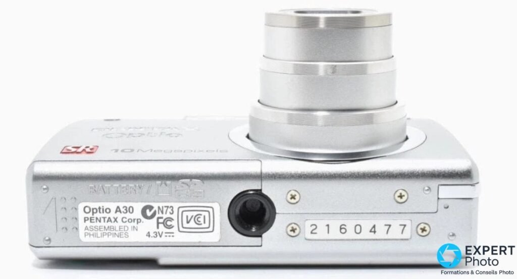 Pentax Optio A30 vu de dessous, étiquette constructeur, filetage trépied, numéro de série et trappe batterie/SD