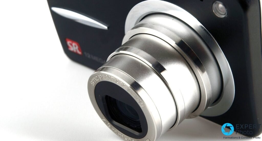 Pentax Optio A40 noir avec zoom smc PENTAX LENS déployé vu en trois-quarts, logo SR 12 mégapixels flou en arrière-plan. 