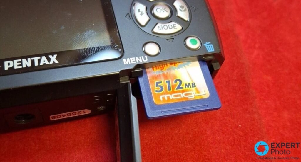 Pentax Optio E50, logement latéral avec carte SD 512 MB partiellement insérée, vue dos rapprochée