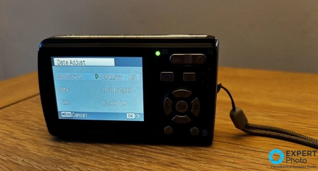 Pentax Optio E60 vu de dos, écran LCD allumé affichant le menu Date Adjust, pavé directionnel et boutons visibles 