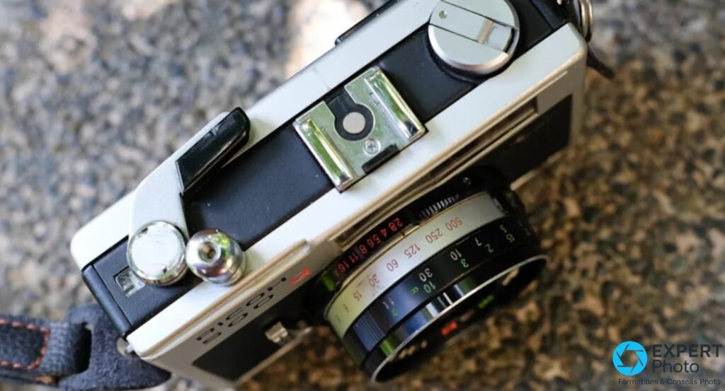 Détail du capot supérieur du Ricoh 500G, griffe flash, déclencheur, bague vitesses 15-500 et ouvertures 2,8-16. 