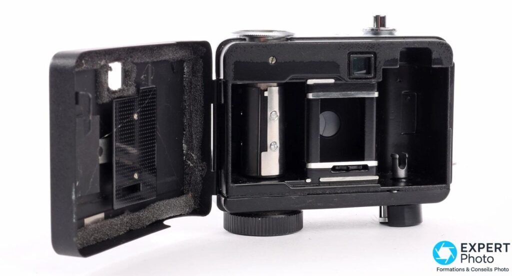 Ricoh Auto Half E avec dos ouvert, compartiment film, fenêtre 24x17 mm et mousses d'étanchéité visibles.