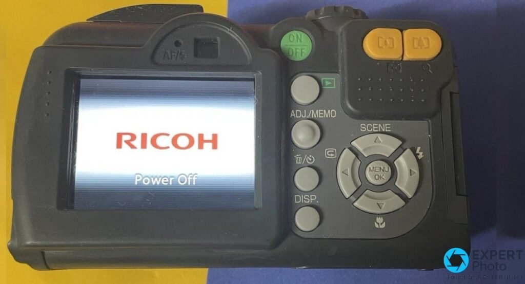  Dos du Ricoh Caplio 500SE avec écran LCD affichant le logo RICOH Power Off et boutons ADJ./MEMO et DISP. 