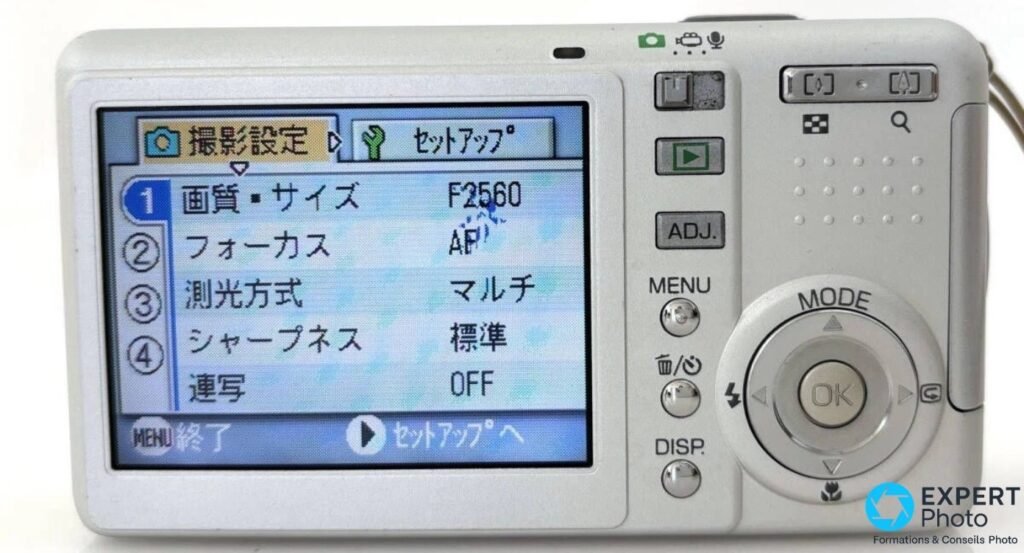  Face arrière du Ricoh Caplio R2 avec écran LCD 2,5 pouces allumé sur le menu de réglages en japonais et boutons MODE OK.