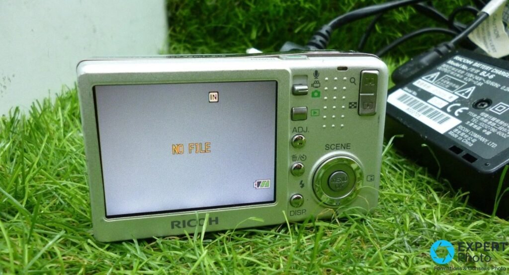 Arrière du Ricoh Caplio R3 avec écran 2,5 pouces affichant NO FILE, pad de navigation et chargeur BJ-6.