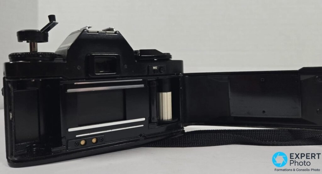 Ricoh XR-S avec dos ouvert, compartiment film et rideau d'obturateur visibles, axe de bobine et mousses noires.