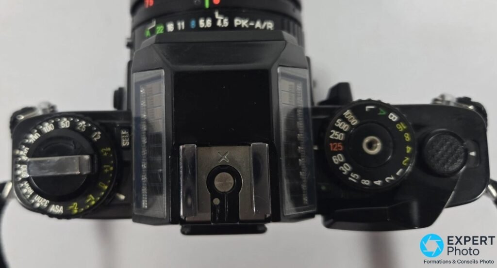 Vue de dessus du Ricoh XR-S : cellules solaires sur le prisme, molettes ASA et vitesses, sabot porte-flash central.