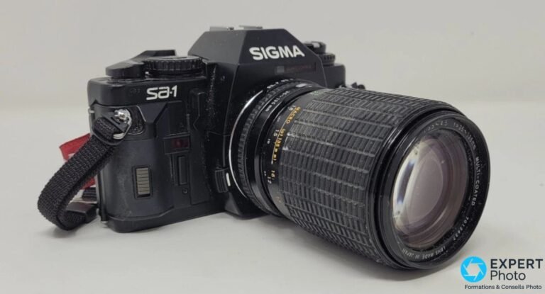 Sigma SA-1 face avant trois-quarts, marquages Sigma, Sa-1 et Quartz Control lisibles, zoom 35-135 mm monté.