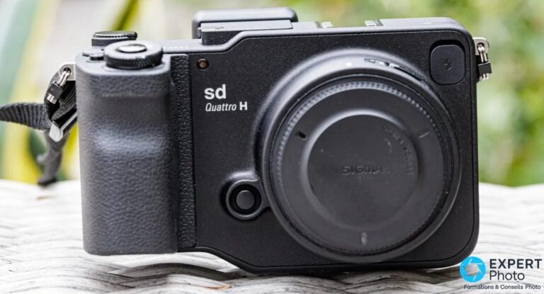 Sigma sd Quattro H posé de face en léger trois-quarts, bouchon de monture SA en place, grip texturé et hot shoe visibles