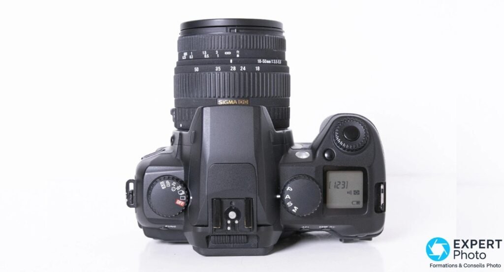 Sigma SD14 vu de dessus, objectif Sigma 18-50mm monté, molette PASM à droite, écran LCD secondaire affichant 123 vues.