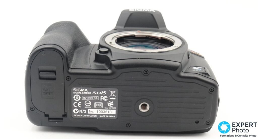 Sigma SD15 vu de dessous, trappe batterie BATT OPEN, étiquette SIGMA MADE IN JAPAN, numéro de série et filetage trépied.