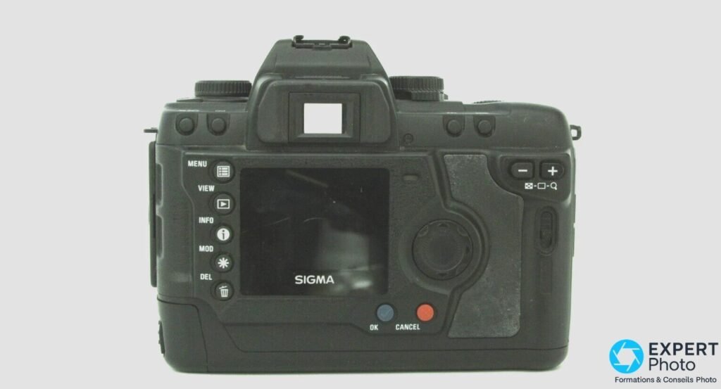 Dos du Sigma SD9 : écran LCD central, boutons MENU, VIEW, INFO, MOD, DEL à gauche, OK et CANCEL en bas, viseur. 