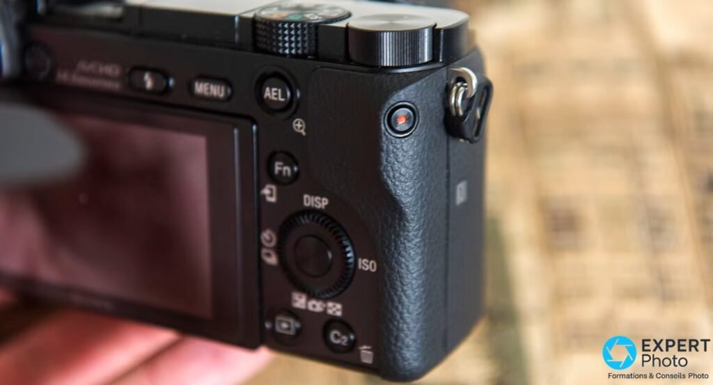 Dos du Sony A6000 en gros plan, boutons MENU, AEL, Fn, molette DISP/ISO, bouton vidéo rouge.