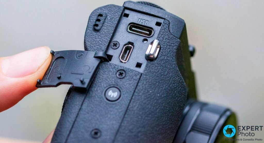Trappe latérale ouverte du G5 X Mark II avec ports USB-C et HDMI mini accessibles, doigt tenant la trappe. 