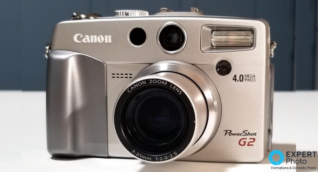  Canon PowerShot G2 argenté vu de face, objectif 7-21mm f/2,0-2,5 déployé, flash, viseur et logo PowerShot G2 visibles