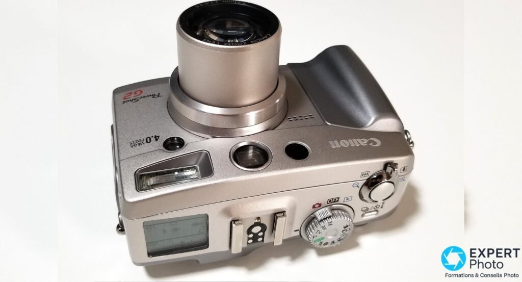 Canon PowerShot G2 vu de dessus : molette PASM, griffe flash ISO, déclencheur, levier zoom et écran LCD de statut 