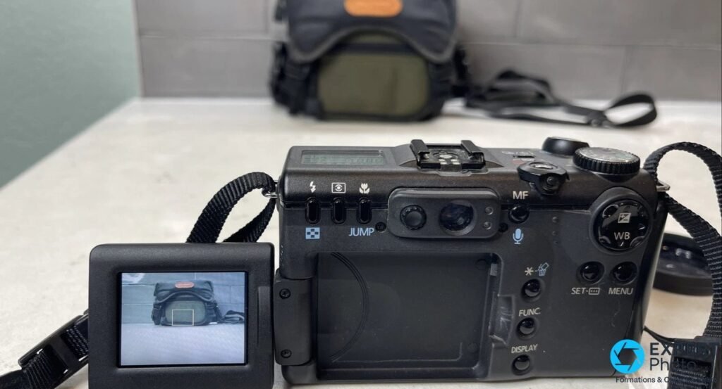 Vue arrière du Canon PowerShot G5 avec écran orientable déplié à gauche, viseur optique central et boutons FUNC, MENU. 