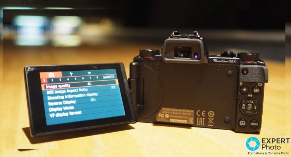Canon PowerShot G5 X de 3/4 dos, écran tactile articulé déployé affichant le menu shooting