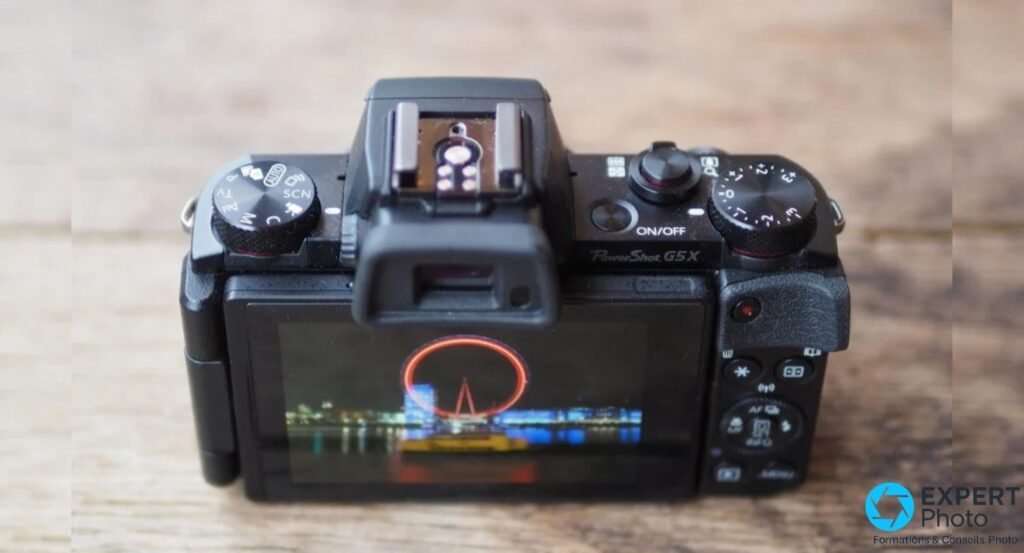 Canon PowerShot G5 X de dos haut, molette de modes, hot-shoe et écran affichant une photo nocturne