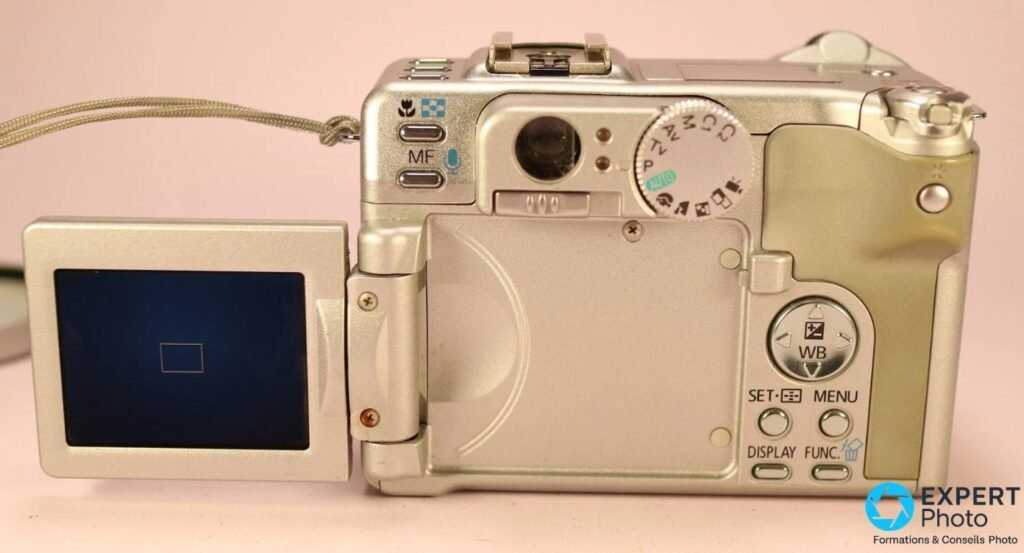 Canon PowerShot G6 vu de dos, écran LCD orientable déplié sur la gauche, molette PASM et viseur optique visibles.