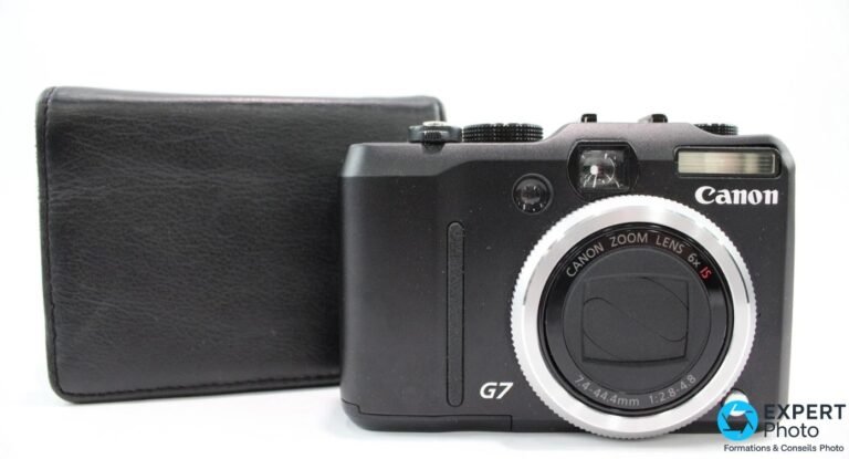 Canon PowerShot G7 vu de face en trois-quarts, objectif rétracté Canon Zoom Lens 6× IS, étui cuir noir derrière.