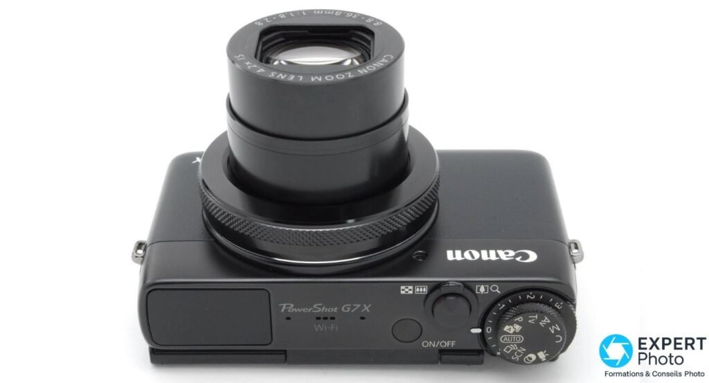 Canon PowerShot G7X vu de dessus, inscription PowerShot G7X Wi-Fi gravée, roue de mode et déclencheur visibles